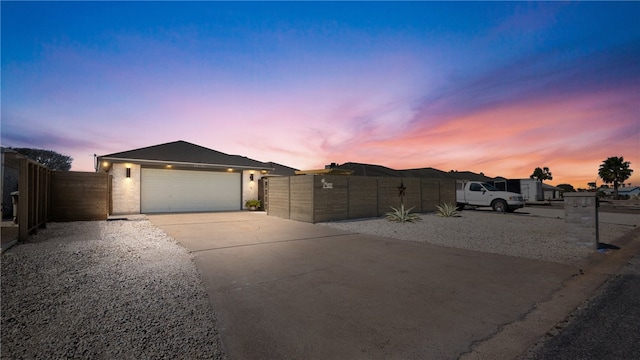 view of front facade featuring a fenced front yard, concrete driveway, a garage, and a gate