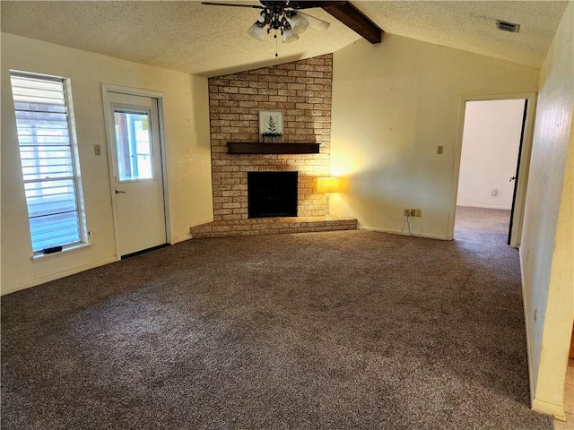 unfurnished living room with a brick fireplace, a textured ceiling, carpet, and vaulted ceiling with beams