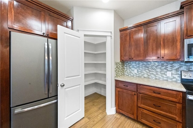 2342 Vaughan Dr, Corpus Christi, TX 78414 - kitchen featuring stainless steel appliances, light wood finished floors, tasteful backsplash, and light stone countertops