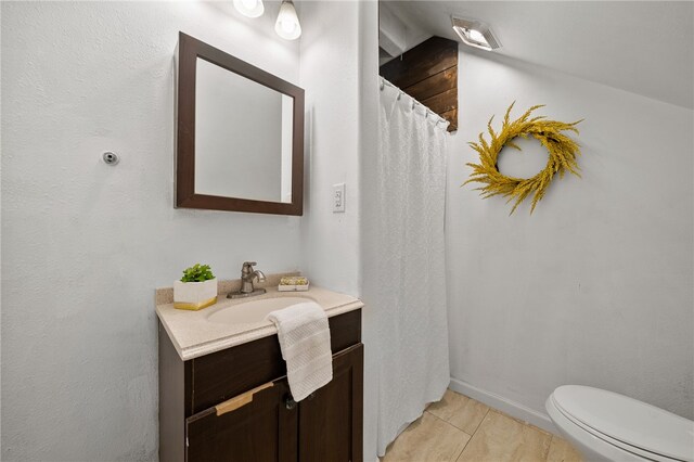 bathroom featuring toilet, vanity, and tile patterned flooring