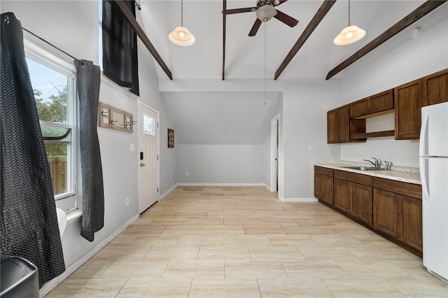 kitchen featuring pendant lighting, beam ceiling, white fridge, and plenty of natural light