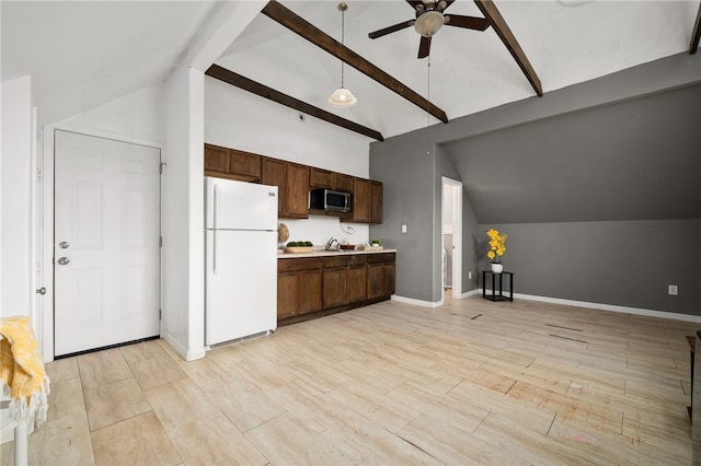 kitchen with vaulted ceiling with beams, ceiling fan, white fridge, and sink