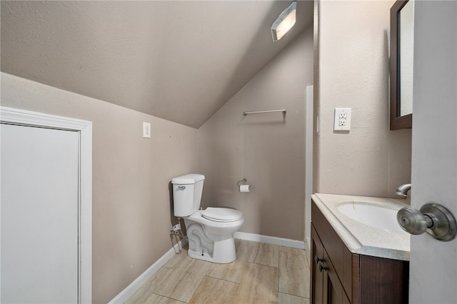 bathroom featuring lofted ceiling, toilet, and vanity