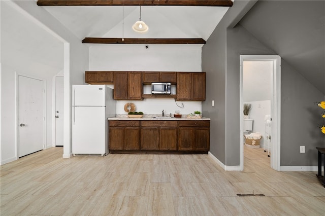 kitchen with light hardwood / wood-style floors, decorative light fixtures, white fridge, and beam ceiling