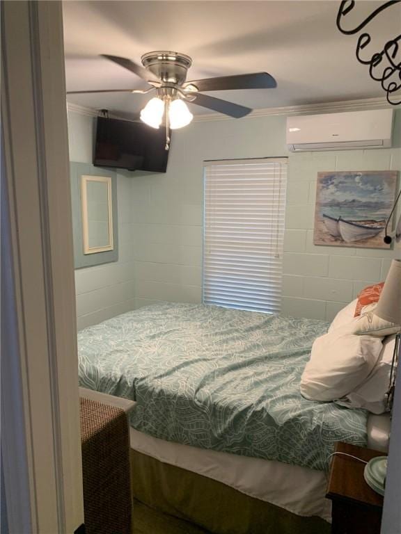 bedroom featuring ornamental molding, ceiling fan, a wall mounted AC, and concrete block wall