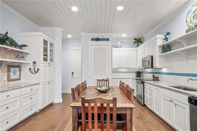 dining area with ornamental molding, sink, wooden ceiling, and light hardwood / wood-style floors