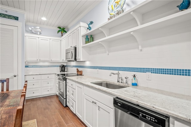 kitchen featuring stainless steel appliances, light stone counters, ornamental molding, white cabinets, and decorative backsplash