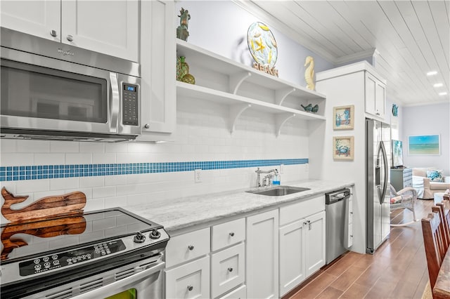 kitchen with white cabinetry, appliances with stainless steel finishes, light stone countertops, and sink