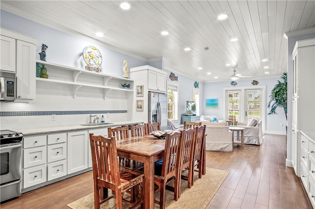 dining room with crown molding, sink, wooden ceiling, and light wood-type flooring