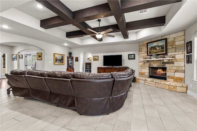 tiled living room featuring a fireplace, coffered ceiling, ceiling fan, and beam ceiling