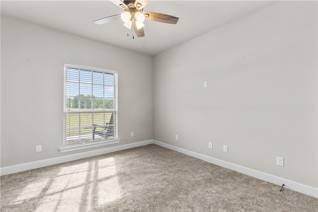 carpeted spare room featuring ceiling fan