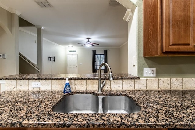 2526 Whirlwind St, Corpus Christi, TX 78414 - kitchen with dark stone counters, ceiling fan, ornamental molding, and brown cabinetry