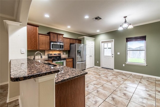 2526 Whirlwind St, Corpus Christi, TX 78414 - kitchen featuring stainless steel appliances, a peninsula, dark stone counters, ornamental molding, and tasteful backsplash