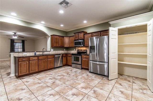 2526 Whirlwind St, Corpus Christi, TX 78414 - kitchen featuring stainless steel appliances, ornamental molding, light tile patterned flooring, tasteful backsplash, and arched walkways
