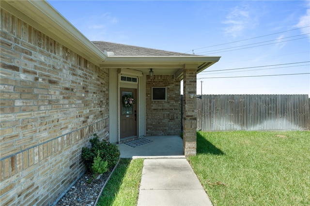 entrance to property featuring a lawn