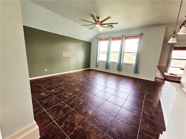 tiled empty room with plenty of natural light, ceiling fan, and vaulted ceiling