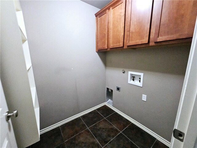 washroom featuring cabinets, electric dryer hookup, gas dryer hookup, hookup for a washing machine, and dark tile patterned flooring