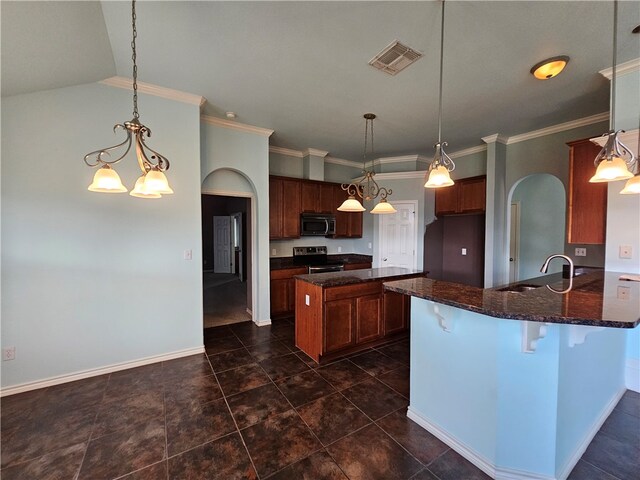 kitchen featuring pendant lighting, stainless steel appliances, dark stone countertops, and an inviting chandelier