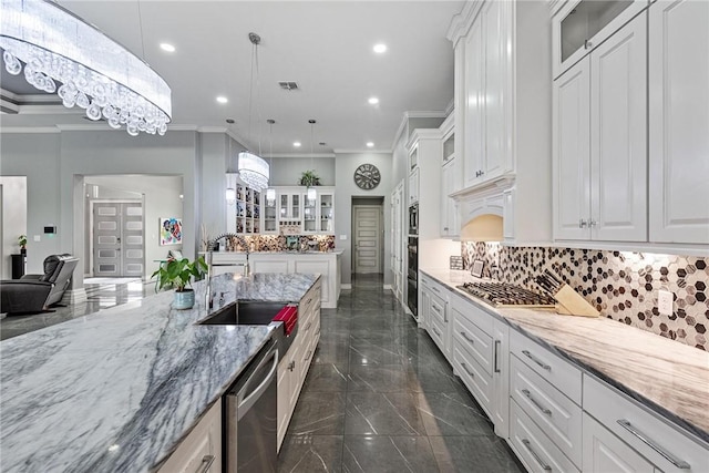 6406 Legacy Pt, Corpus Christi, TX 78414 - kitchen with ornamental molding, white cabinets, light stone counters, a sink, and stainless steel appliances