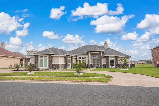 6406 Legacy Pt, Corpus Christi, TX 78414 - view of front facade with a front yard, curved driveway, a chimney, and stone siding