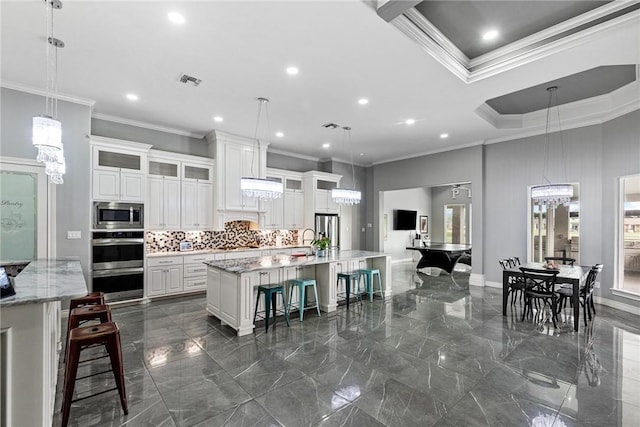 6406 Legacy Pt, Corpus Christi, TX 78414 - kitchen featuring crown molding, appliances with stainless steel finishes, a large island with sink, and marble finish floor