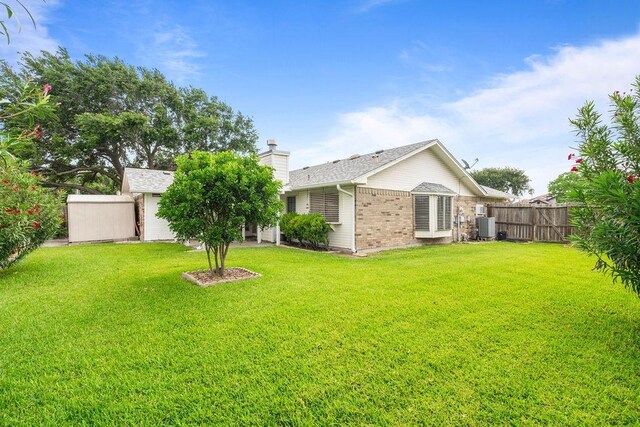 2441 Windsong Dr, Corpus Christi, TX 78414 - back of property featuring brick siding, central air condition unit, and a chimney