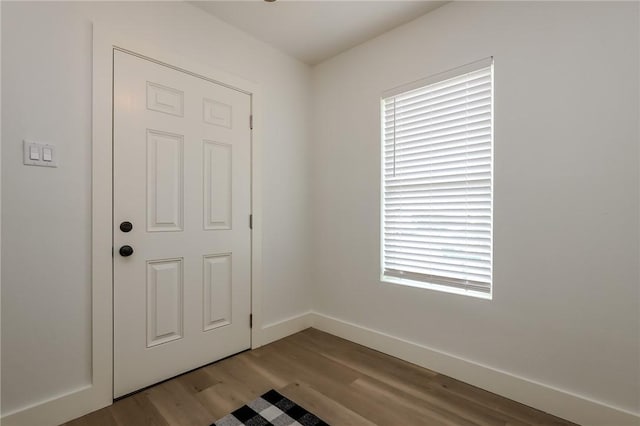 interior space with baseboards and wood finished floors