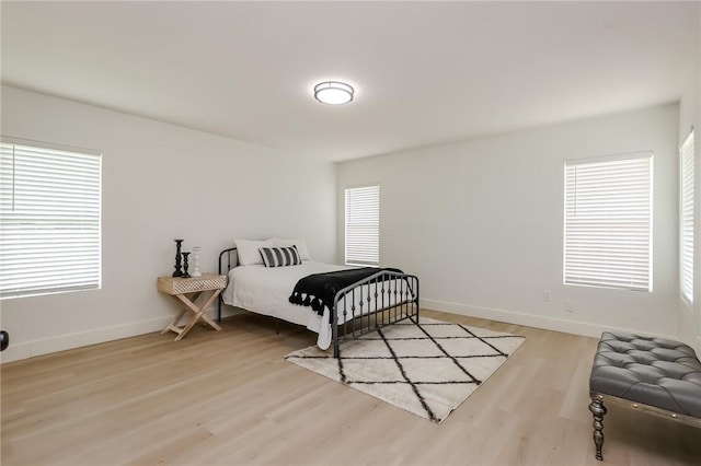 bedroom with light wood-style floors and baseboards