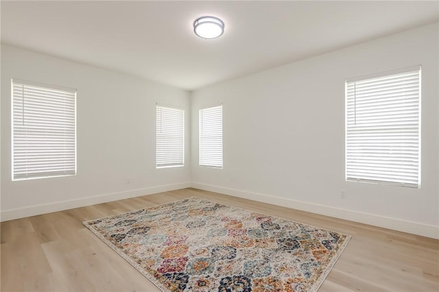 empty room featuring baseboards and light wood-type flooring