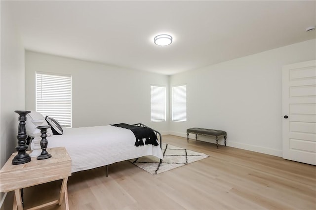 bedroom featuring baseboards and light wood finished floors