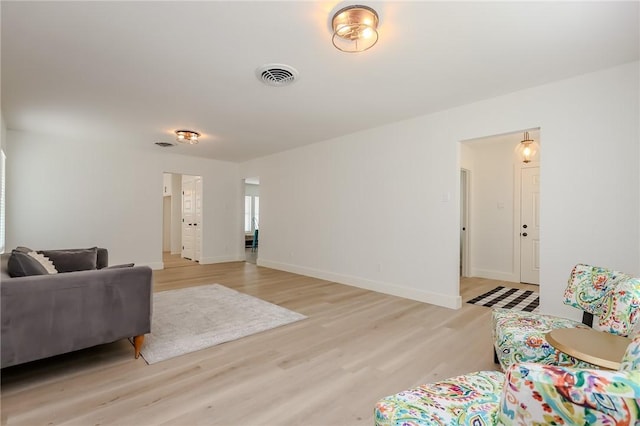 living room with baseboards, light wood-style flooring, and visible vents