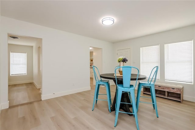 dining area featuring baseboards, visible vents, and light wood-style flooring