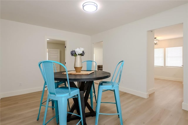 dining room featuring baseboards and light wood finished floors
