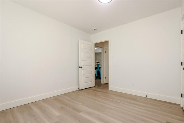unfurnished room featuring baseboards and light wood finished floors