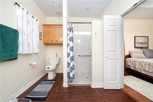 bathroom with toilet, wood-type flooring, and a shower with curtain