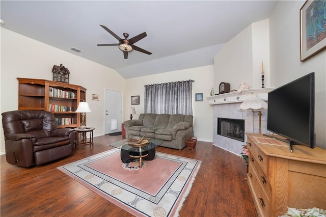 living room featuring ceiling fan, dark hardwood / wood-style flooring, lofted ceiling, and a fireplace