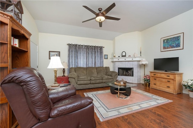 living room with ceiling fan, wood-type flooring, a fireplace, and vaulted ceiling