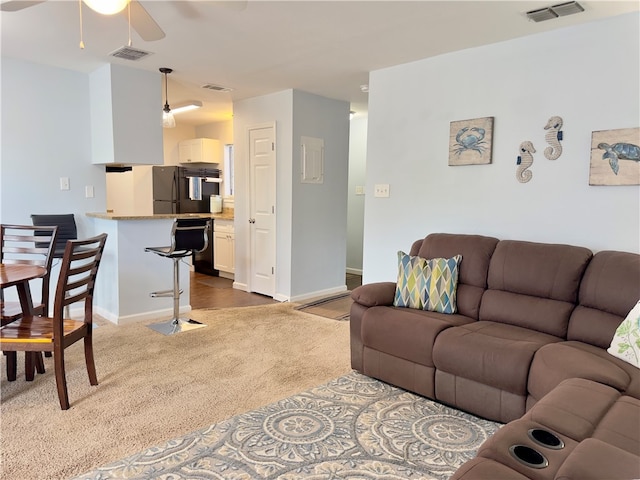 carpeted living room with ceiling fan