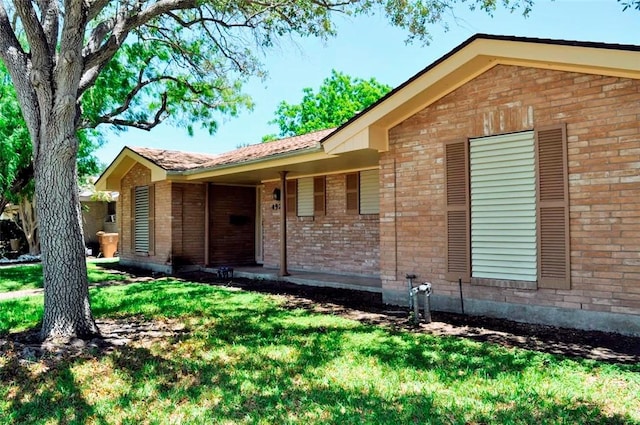 ranch-style home featuring brick siding and a front yard