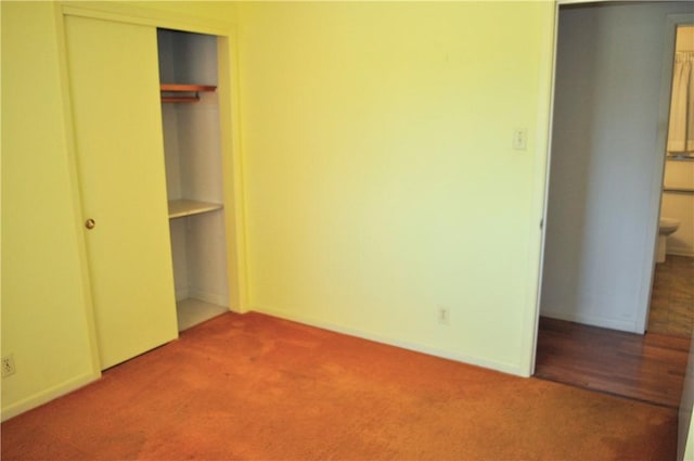 unfurnished bedroom featuring carpet floors, baseboards, and a closet