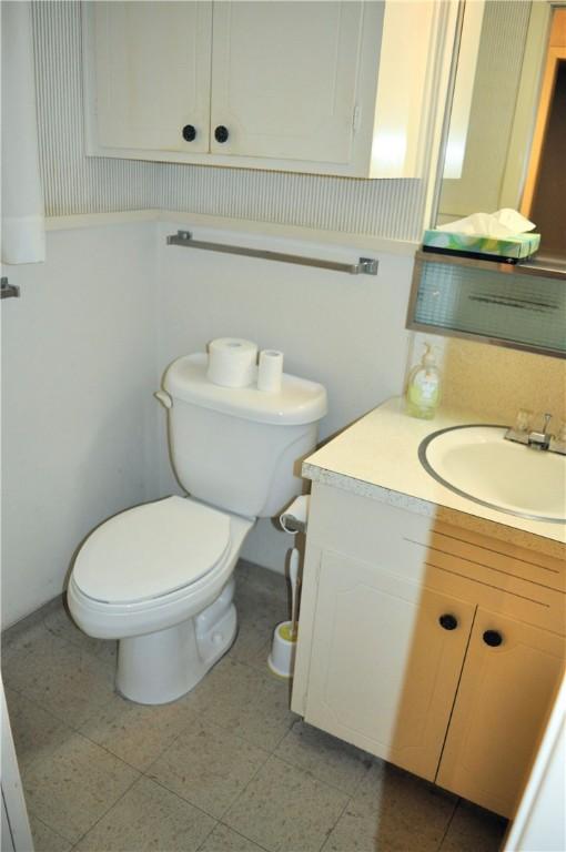 half bathroom with vanity and toilet