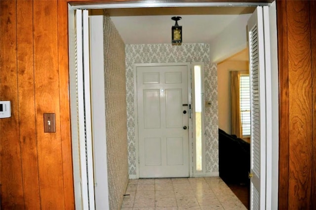foyer entrance featuring wallpapered walls and baseboards