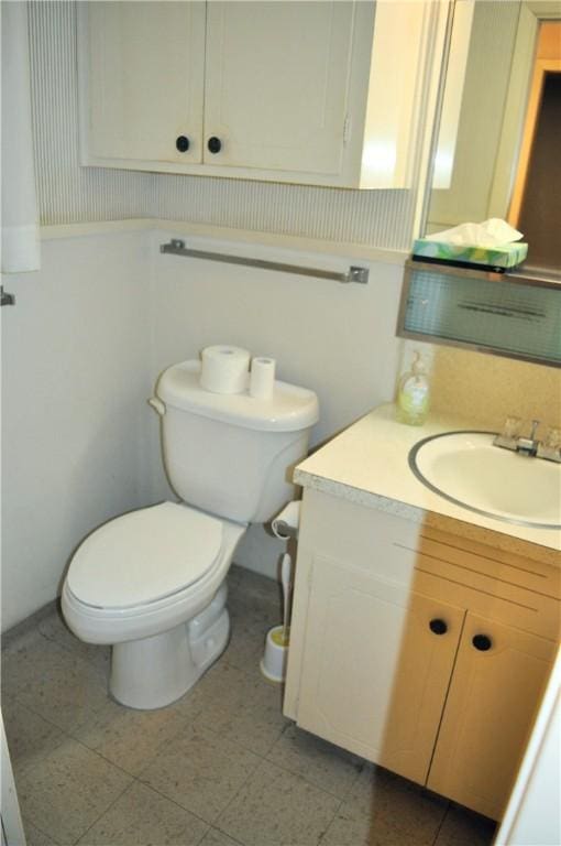 half bath featuring vanity and toilet