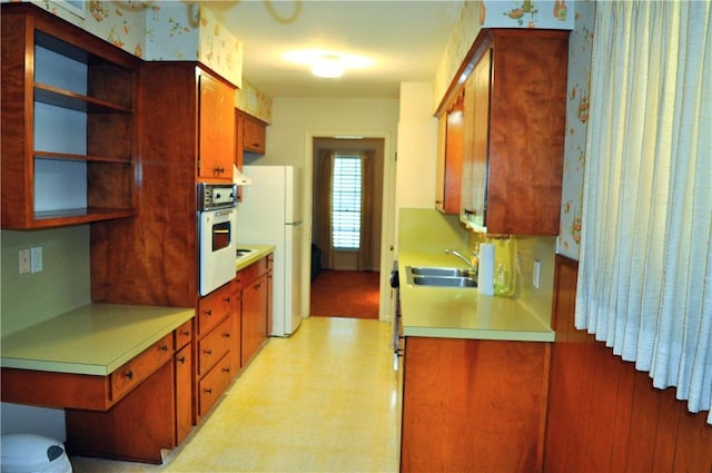 kitchen with white appliances, a sink, light countertops, light flooring, and open shelves