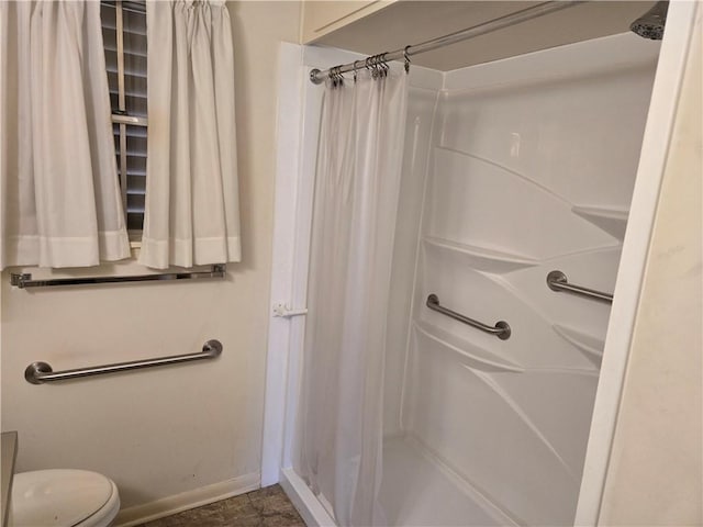 bathroom featuring baseboards, curtained shower, and toilet