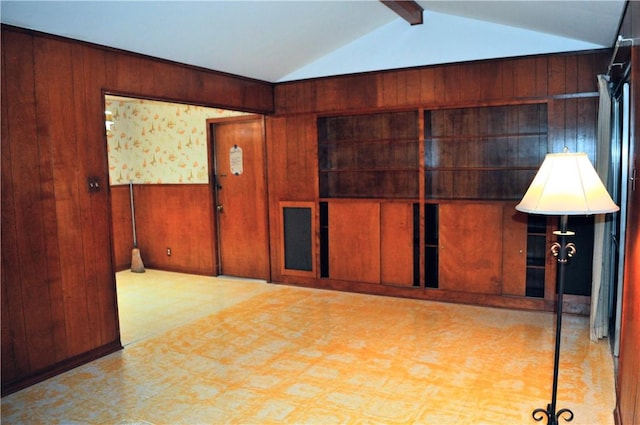 spare room with tile patterned floors, wood walls, and lofted ceiling