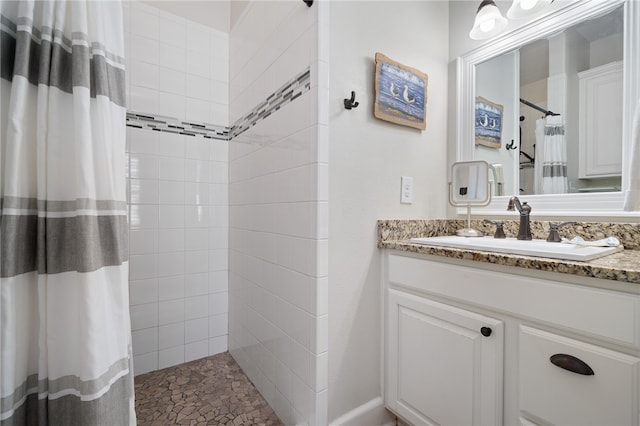 bathroom featuring walk in shower and vanity