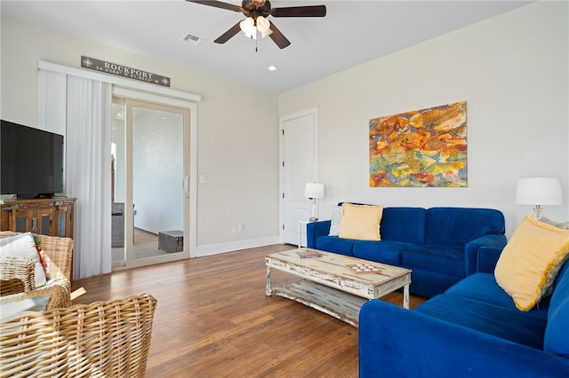 living room featuring dark wood-type flooring and ceiling fan