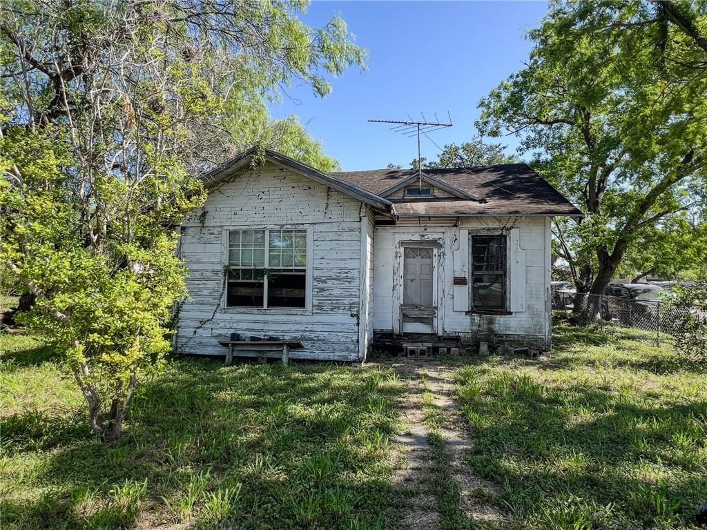 bungalow-style house featuring a front yard and fence