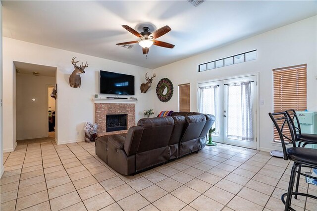 705 Aurora St, Bishop, TX 78343 - living room featuring light tile patterned floors, ceiling fan, a fireplace, and baseboards